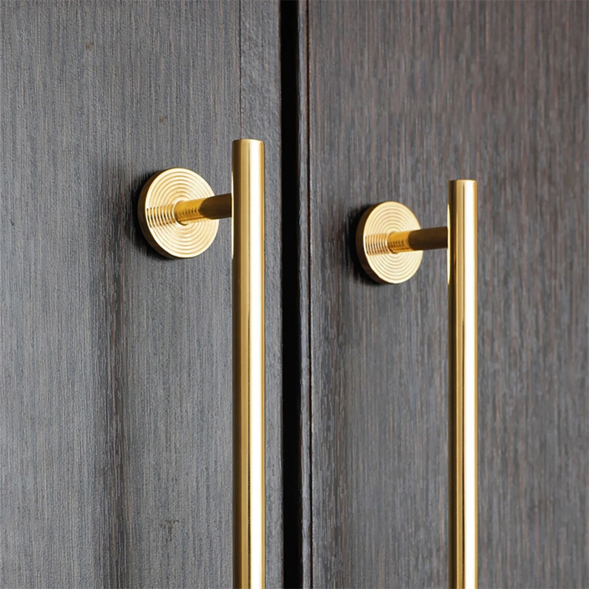 Minimalist brass concentric ring handles by Brass Essence, close-up showing sleek, modern design with circular rings and smooth finish.
