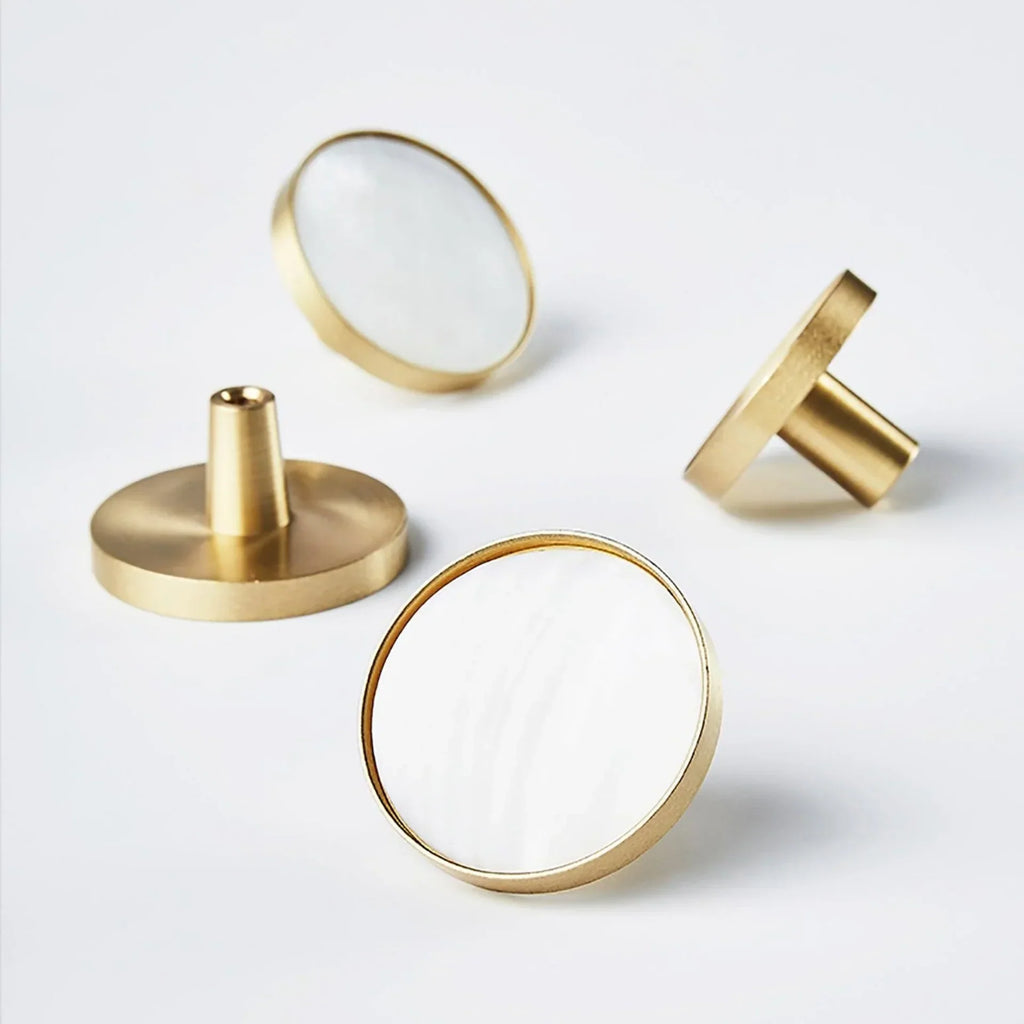 Mother of pearl and brass round cabinet knob by Brass Essence, showcasing a glossy pearl surface with brass accents.