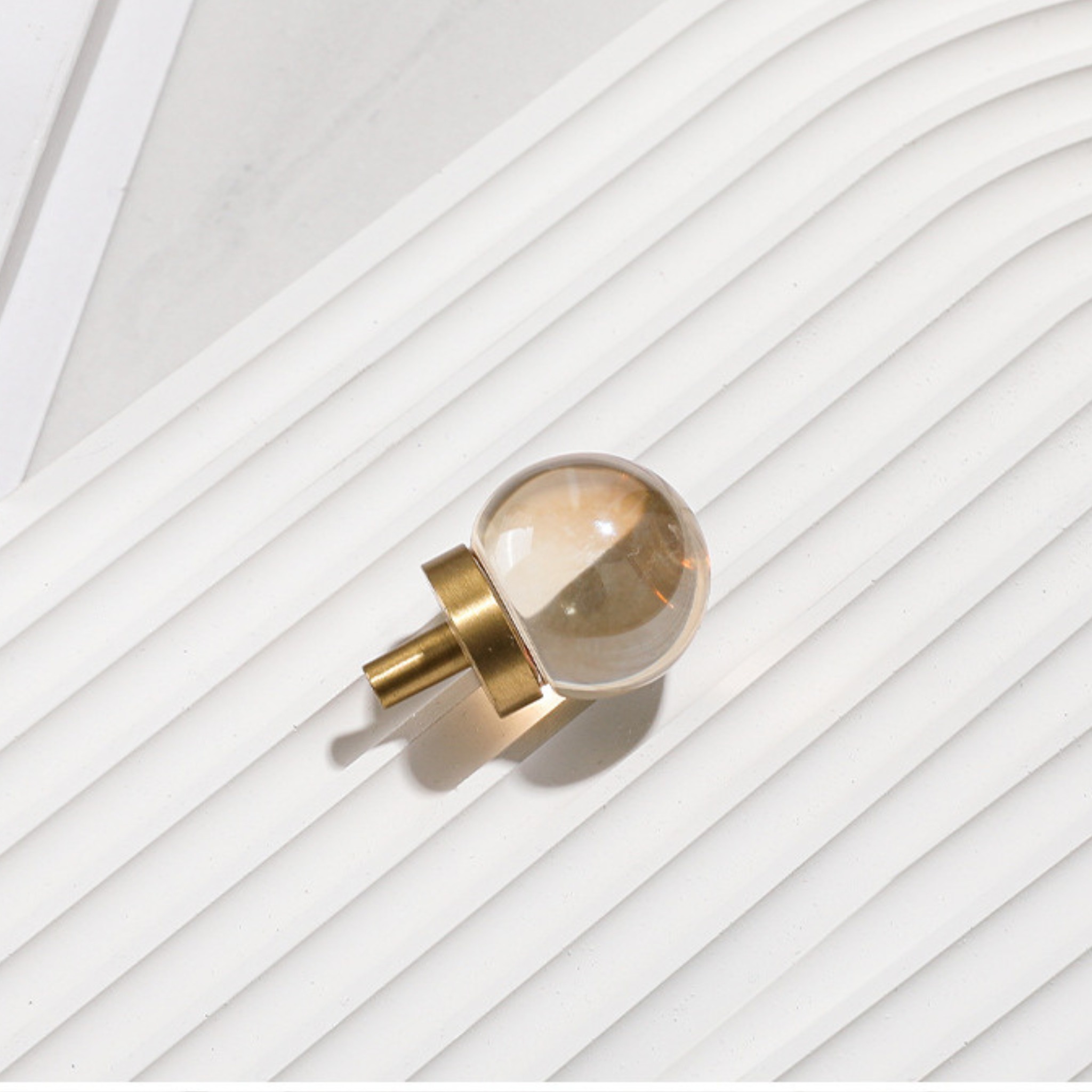 Brass Essence natural crystal ball and brass cabinet knob with intricate design, suitable for furniture or decor accents.
