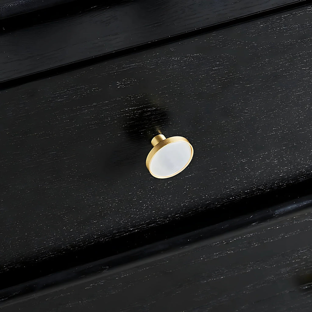 Mother of pearl and brass round cabinet knob by Brass Essence, showing a shiny pearl-inlaid surface with brass accents.