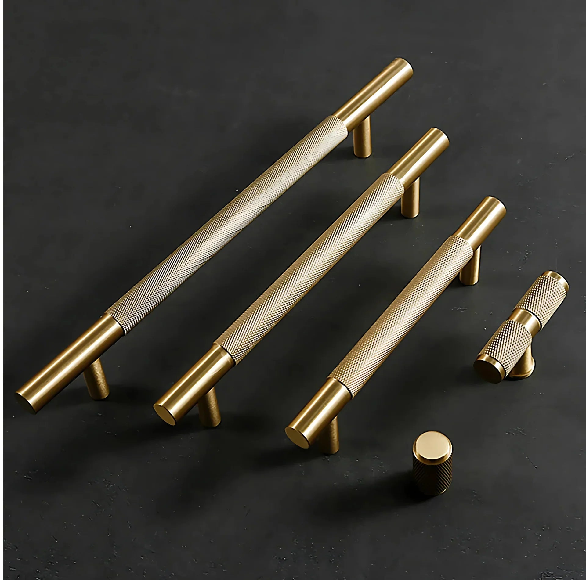 Set of gold cabinet handles on a black background