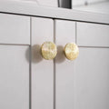 Pair of hammered brass half-circle pulls from Brass Essence, showing textured finish and sleek curved design for furniture or cabinets.