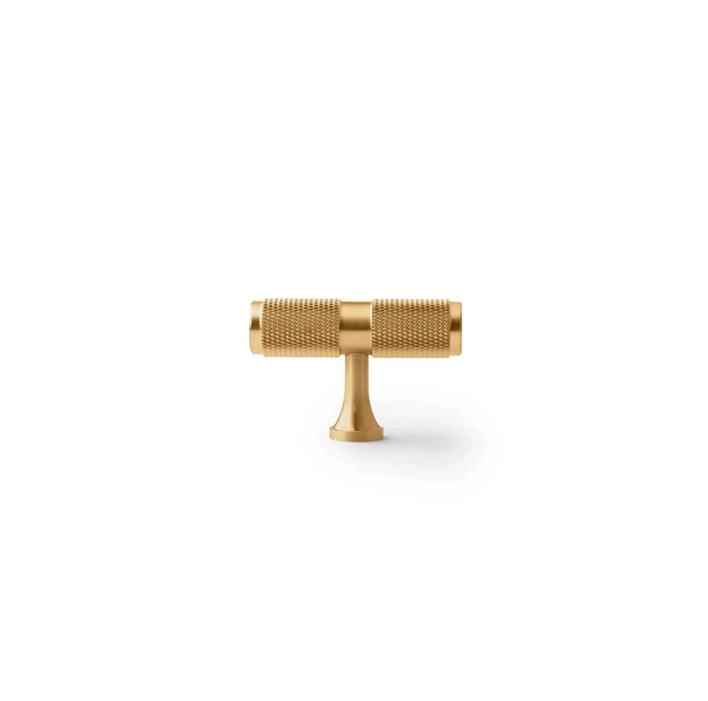 Gold T-shaped tool on a white background