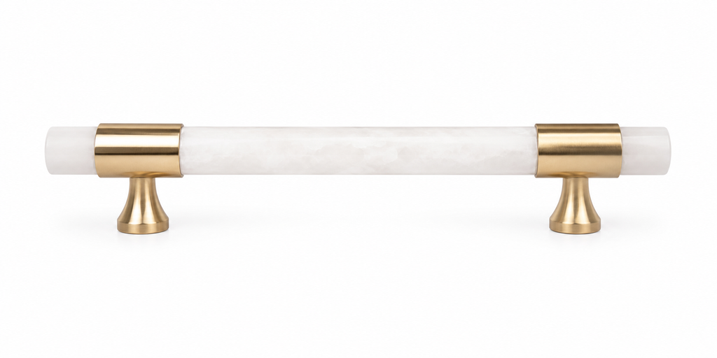 A modern cabinet pull handle featuring a white marble inlay with subtle gray veining and polished gold-finished metal brackets and posts, shown against a solid white background.