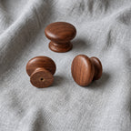 Tectona walnut wooden cabinet knobs on grey fabric showing front, side and rear views – Brass Essence