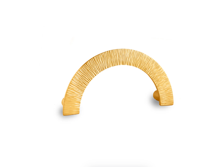 A modern gold metal cabinet pull handle with a textured, vertically ribbed finish, shown on a plain white background.